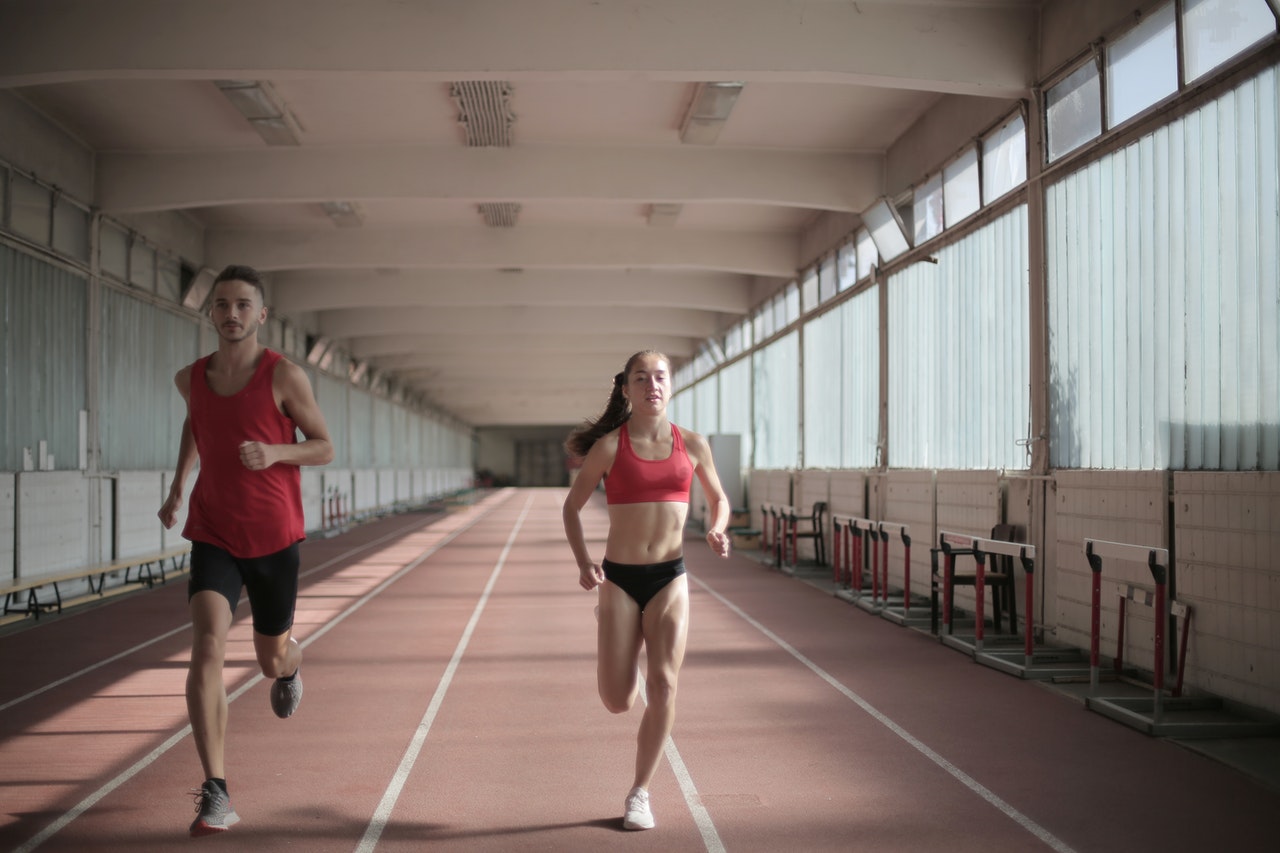 man and woman running on a track