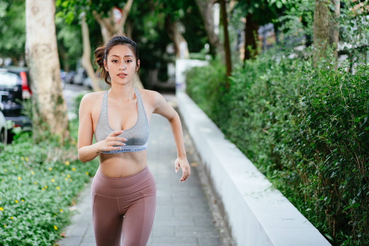 woman in shape running outside